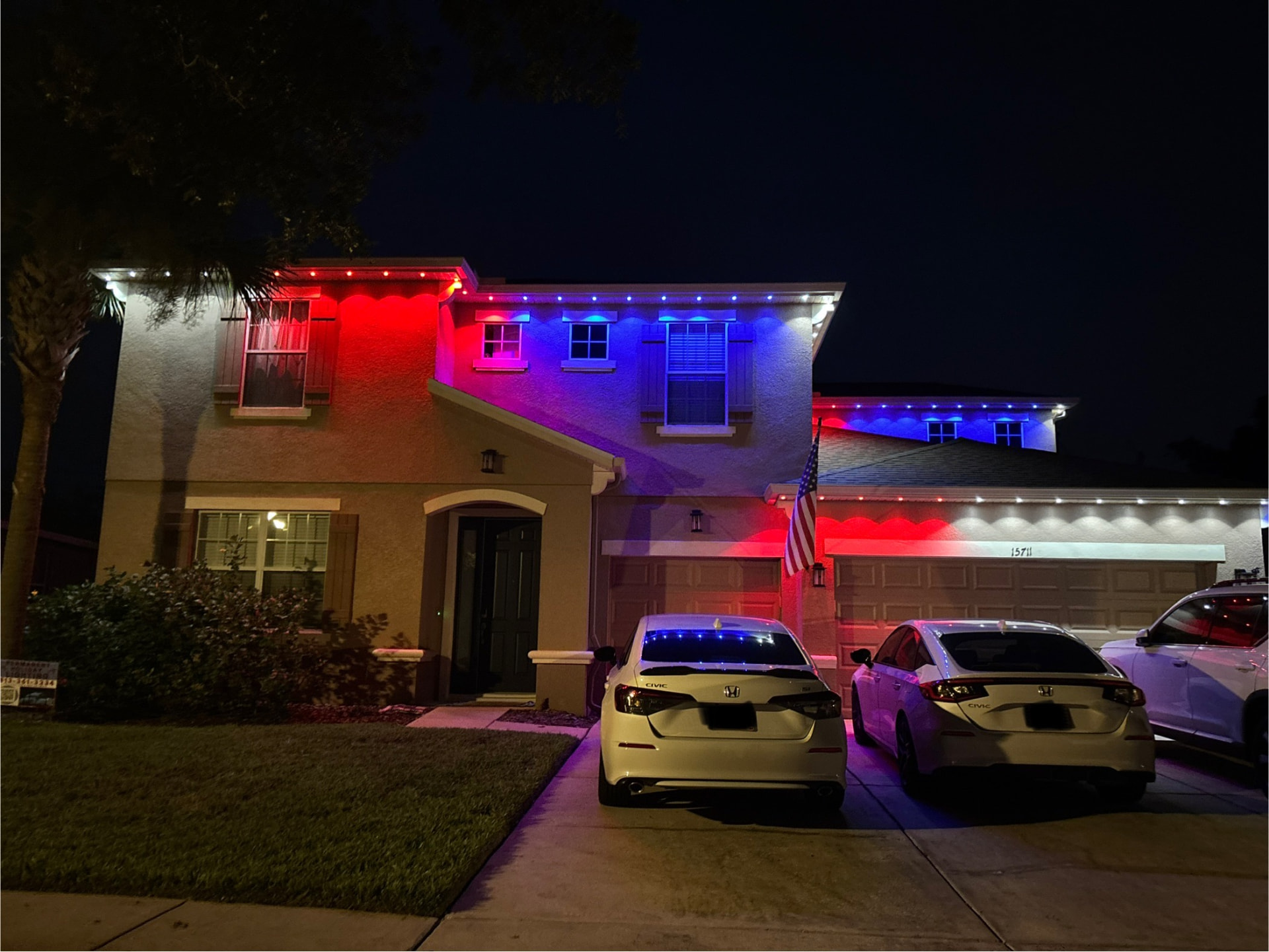 Home illuminated with red, white, and blue permanent exterior lighting